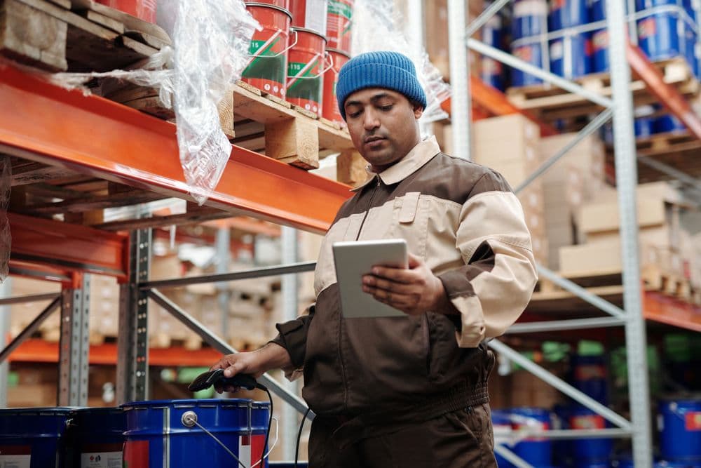 Warehouse worker tracking shipments with a tablet